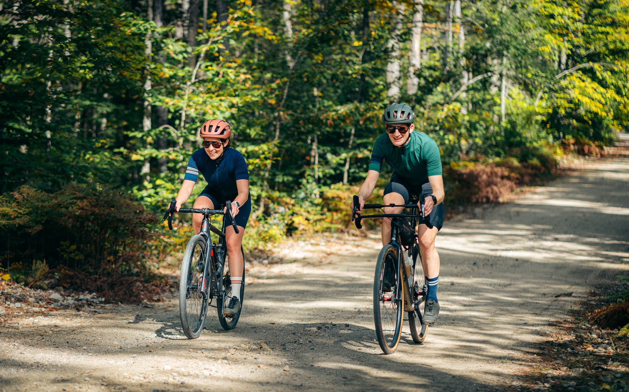 Two cyclists riding on a forest path