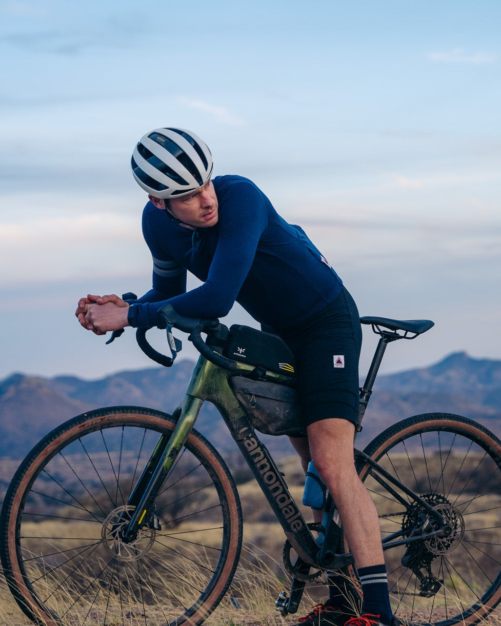 Person on a bicycle in a desert landscape with mountains in the background