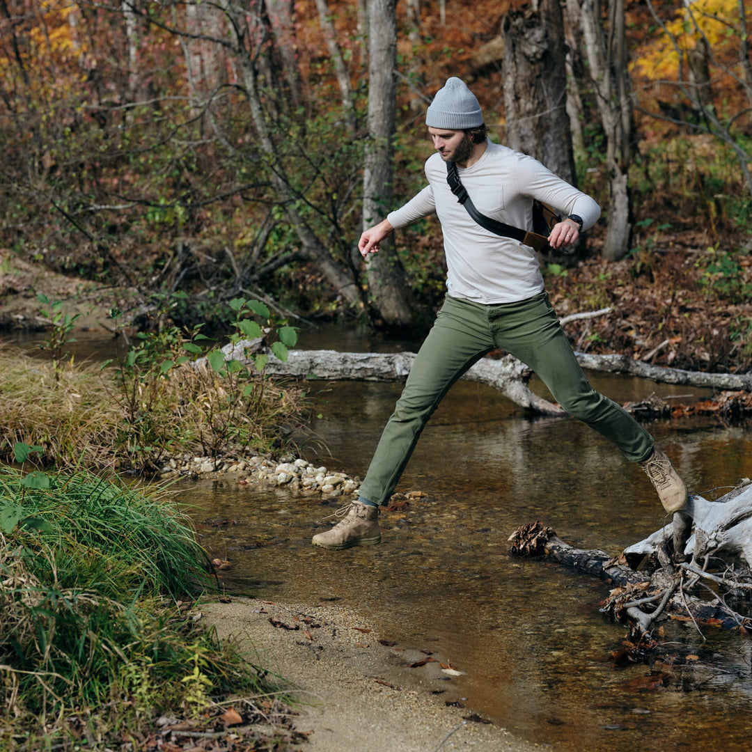 Pinebury Greenwood Long Sleeve Performance Tee in Moonbeam, Man Jumping over creek in the Fall in Maine