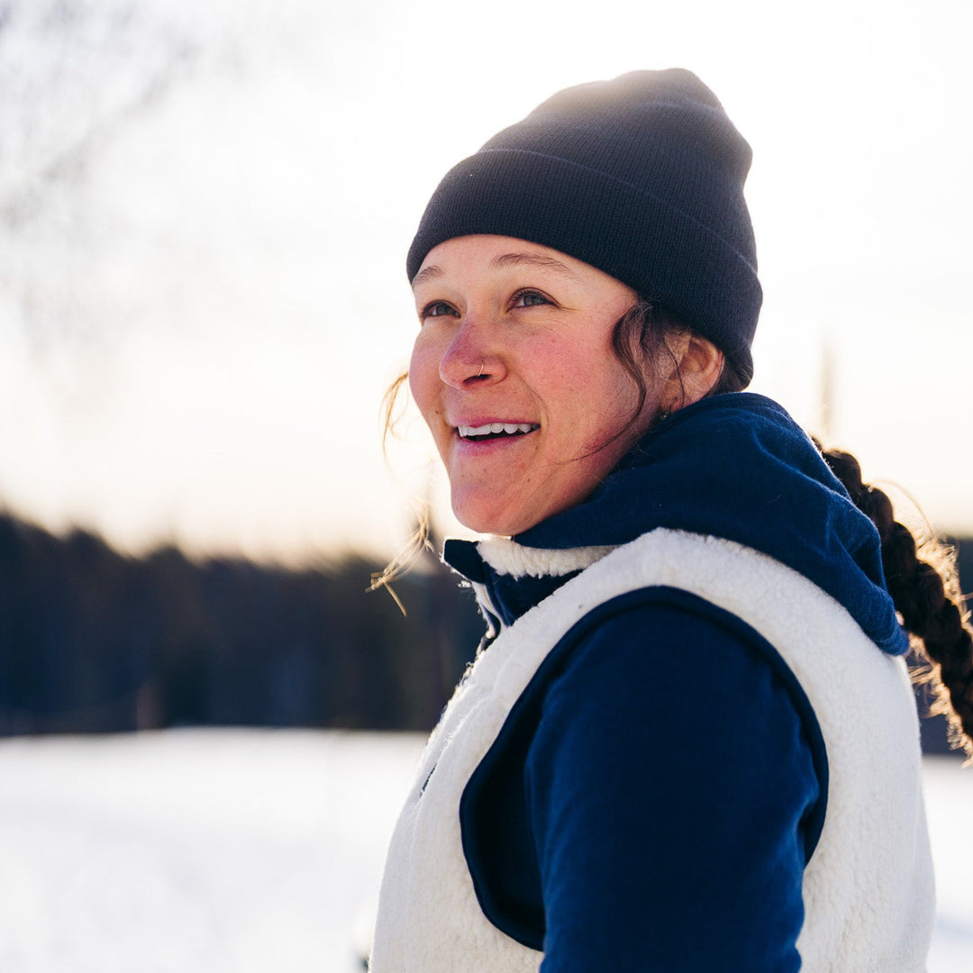 Woman in winter clothing standing by a snowy landscape