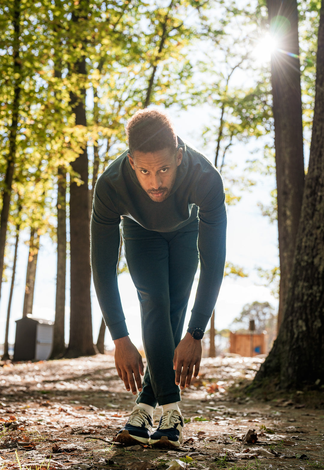 Person in athletic wear preparing to run in a forest setting