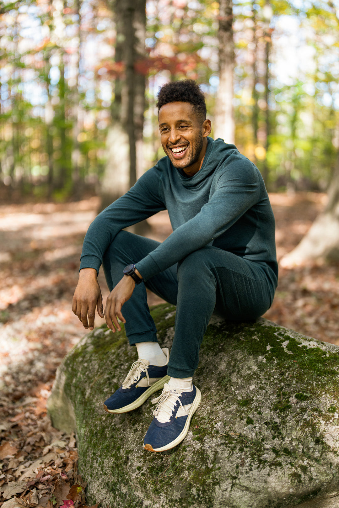 Man sitting on a rock in a forest during autumn