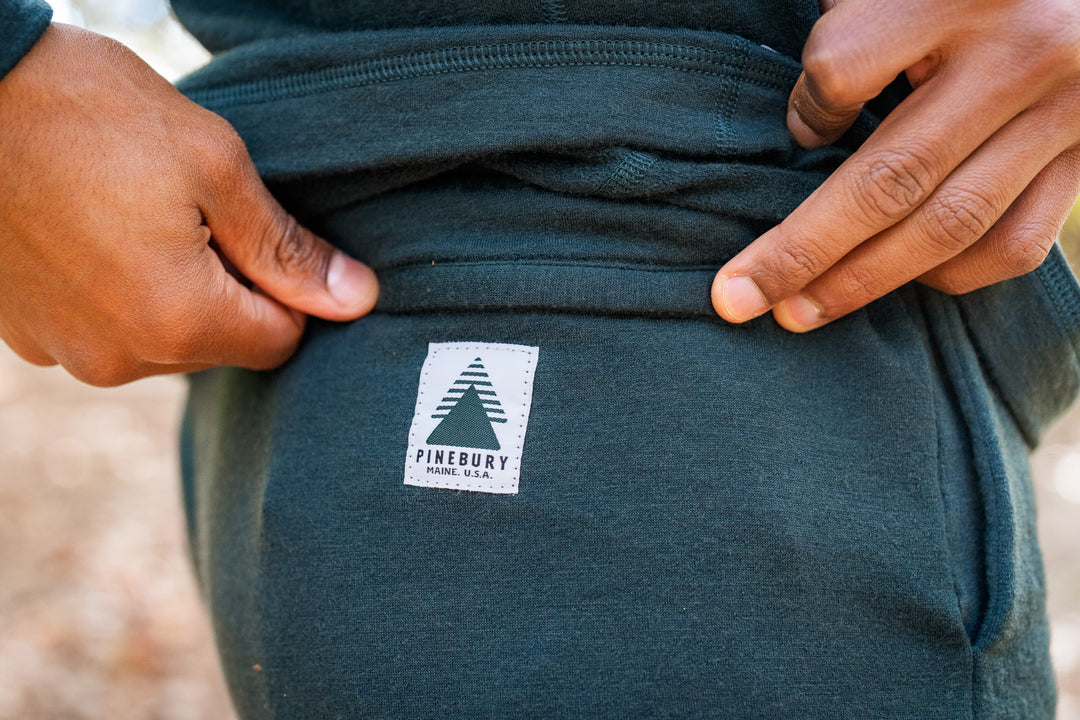 Green sweatshirt with a visible brand logo on the back pocket.