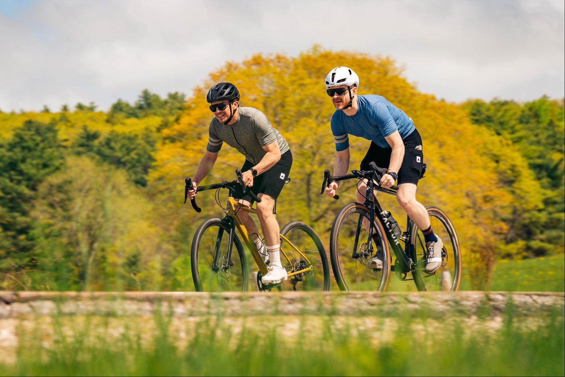 Two cyclists riding on a path with trees in the background