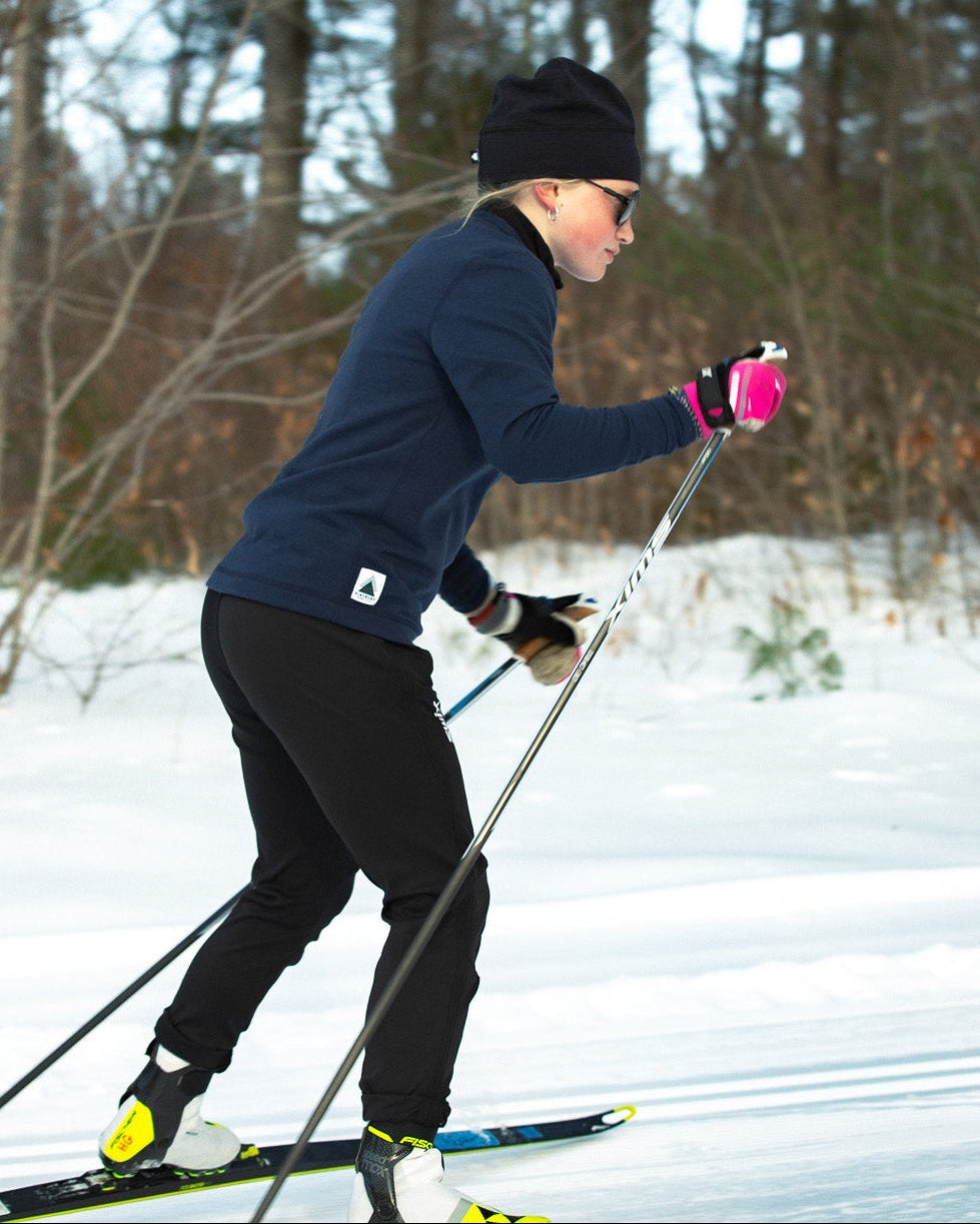 Person cross-country skiing in a snowy forest