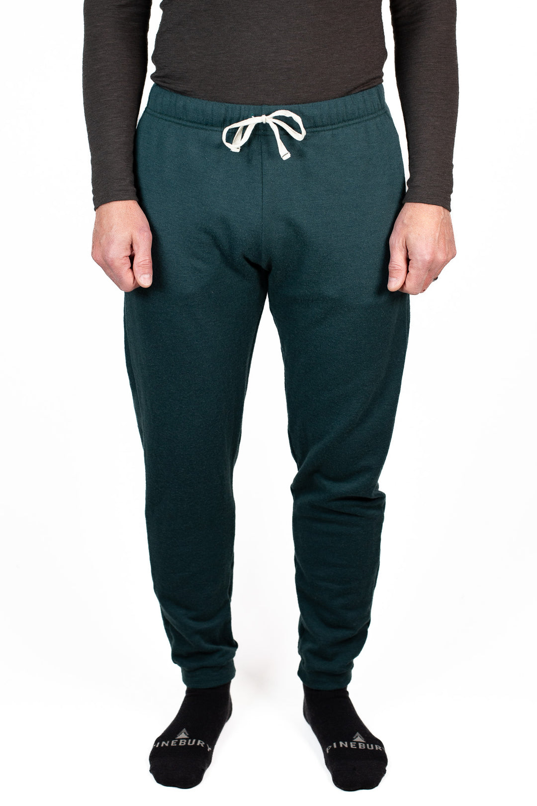 Person wearing teal jogger pants with a white drawstring on a white background