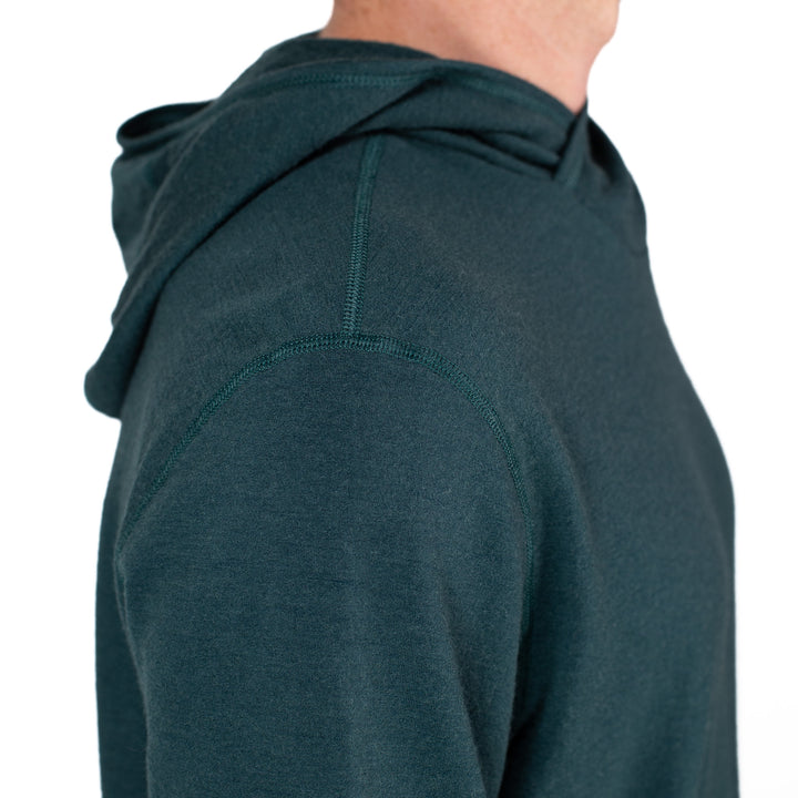 Teal hoodie worn by a person on a white background