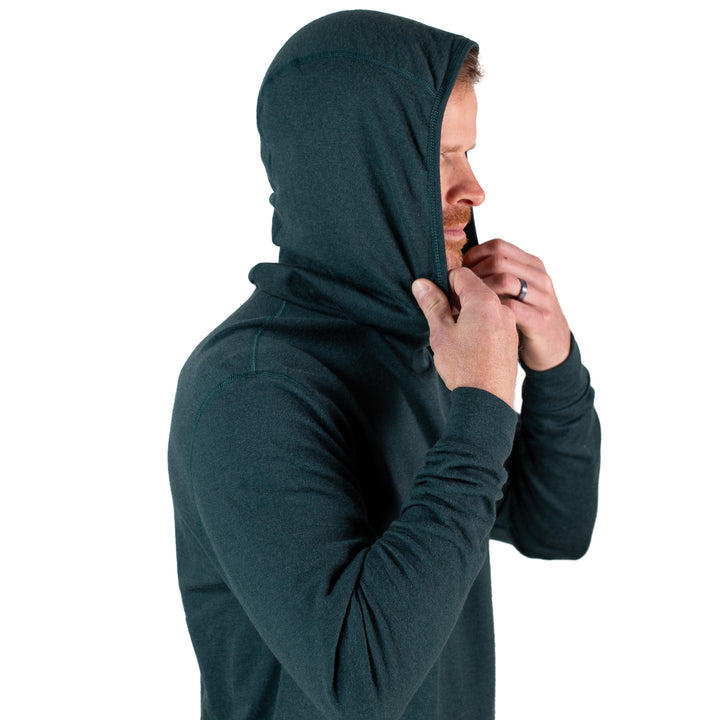 Person wearing a dark green hoodie on a white background