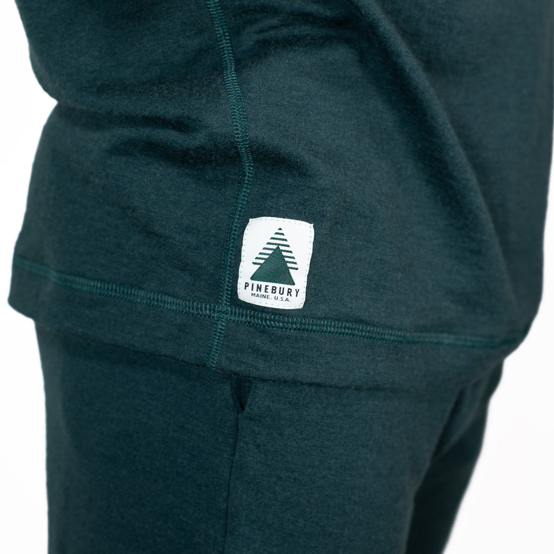 Dark green hoodie with a visible brand logo on a white background