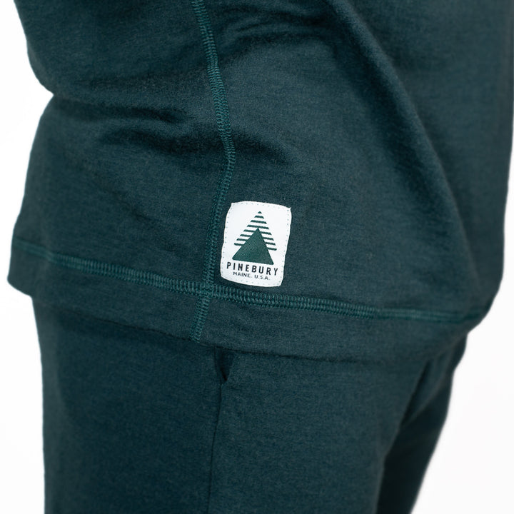 Dark green hoodie with a visible brand logo on a white background