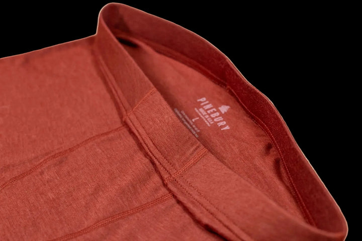 Close-up of a red garment with a brand logo on a white background