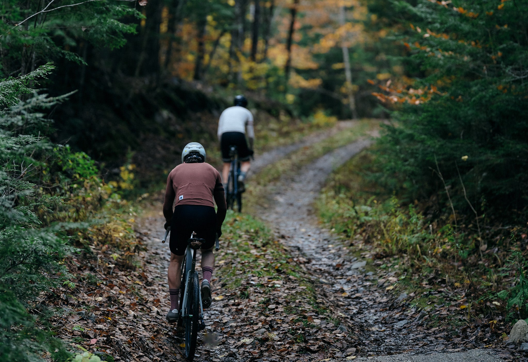 Pinebury Grafton Long Sleeve Merino Wool Jersey. Gravel Cyclists riding up a double track in Maine in the late Fall.