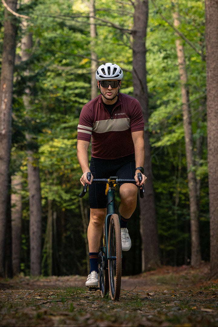 Riding a forest trail in the Brick Red Every-Season Quarter Zip Jersey