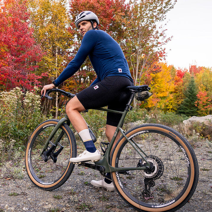 Rider in Pinebury merino wool bib shorts on a fall gravel ride in Maine