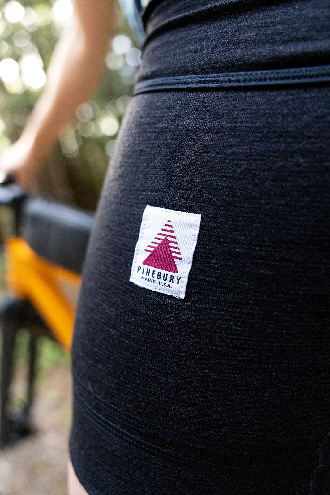 Close-up of the Charcoal heather Nuyarn merino wool fabric and Pinebury label