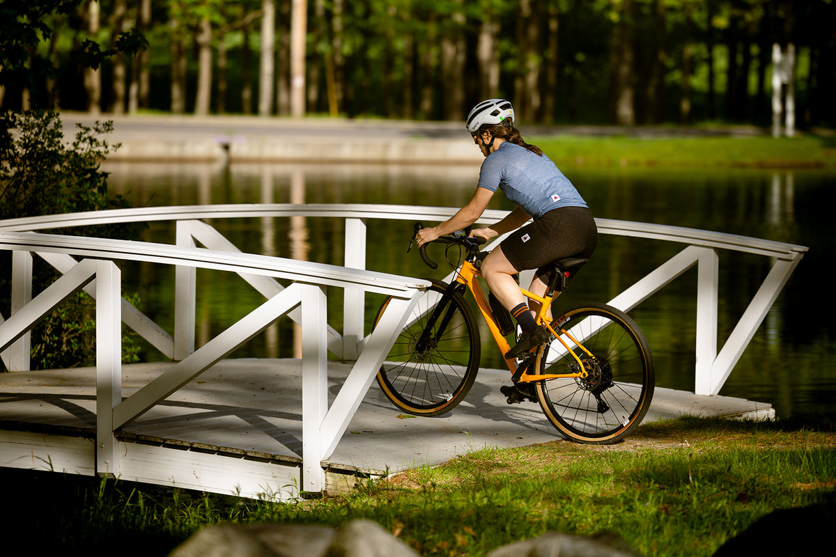 Rider crossing a footbridge in Pinebury women's merino wool bib shorts