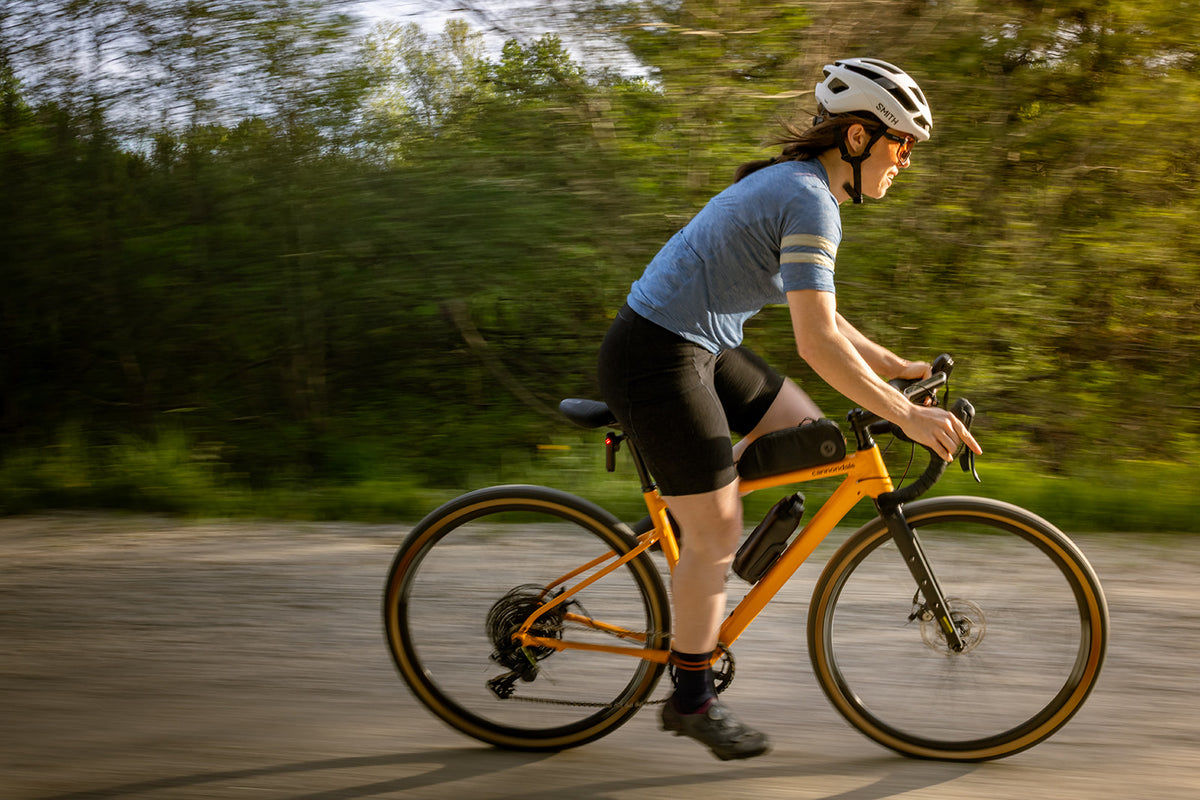 Rider on a paved road in Pinebury women's merino wool bib shorts