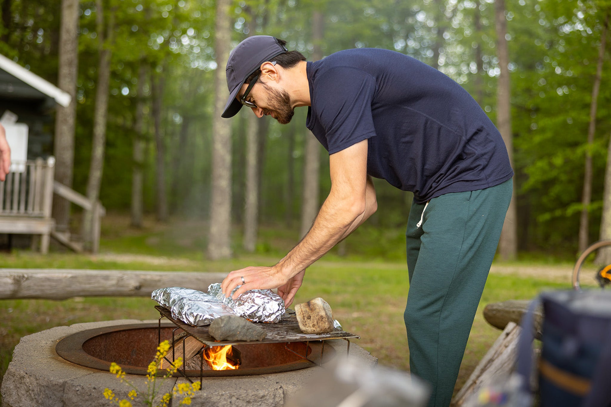 Man cooking over a campfire in a forest setting
