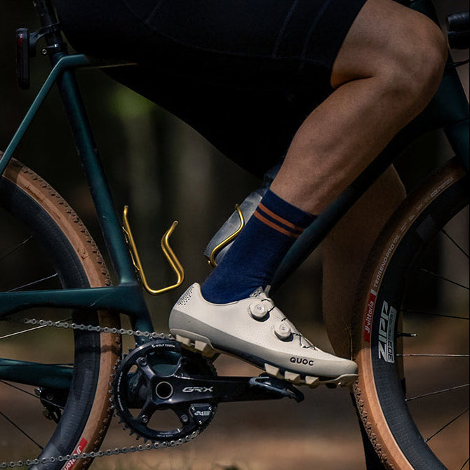 Close-up of the Summer Merino Wool Sock v2 in Navy with burnt orange stripes on a gravel ride